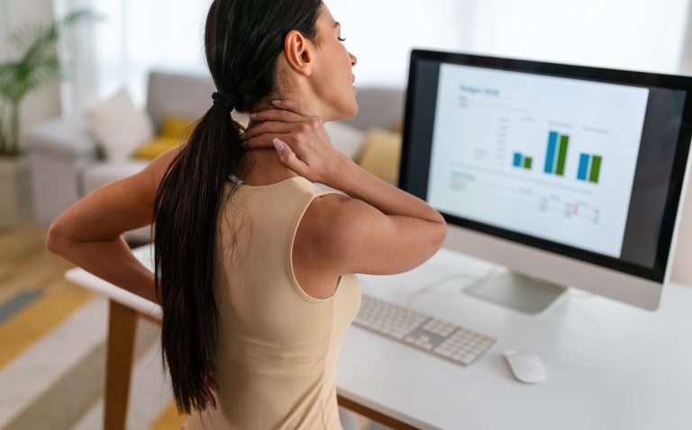 Massage for TMJ Camrose 5 Woman experiencing neck pain while working from home before visiting a physiotherapy clinic